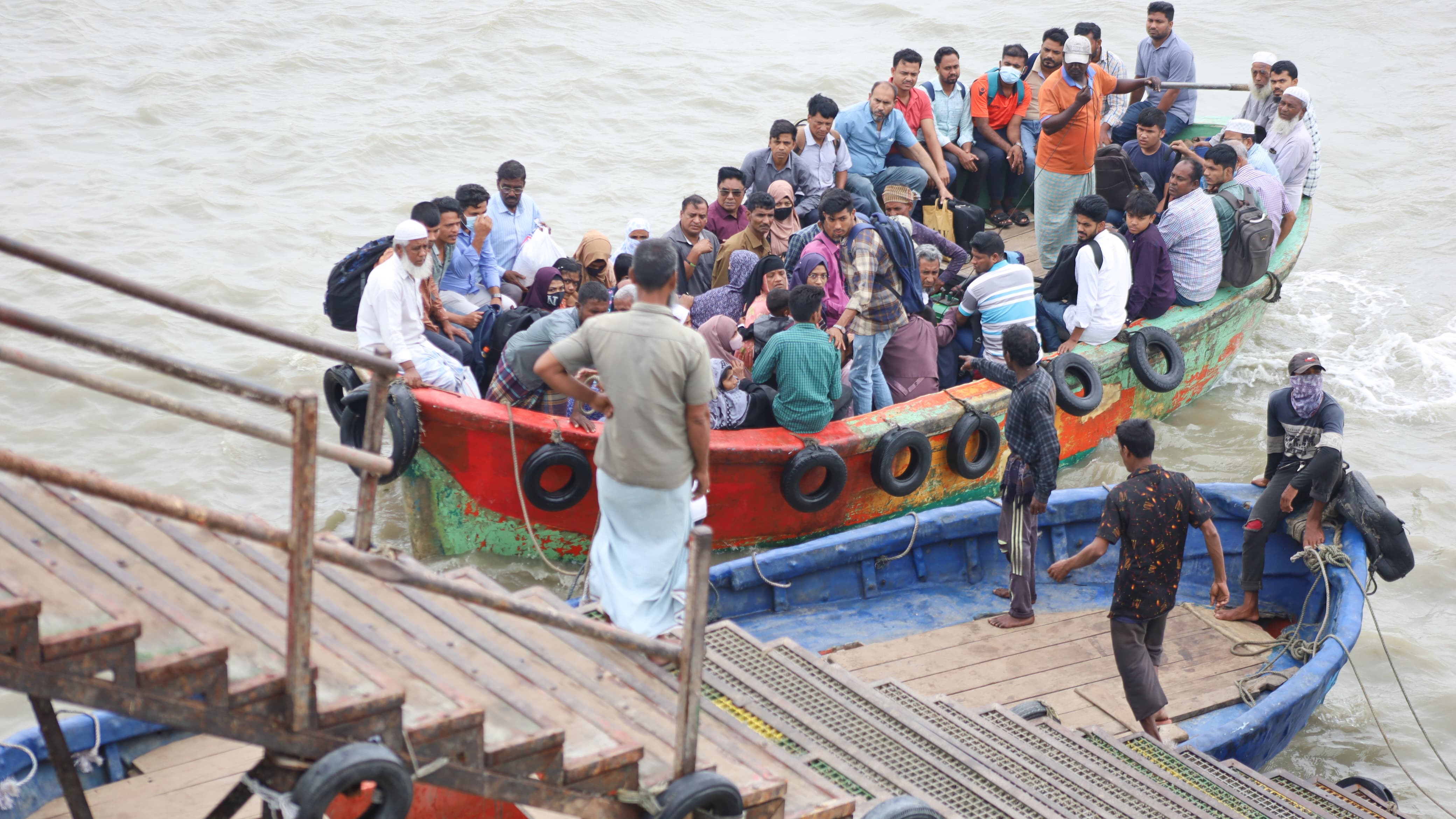 লাল বোট থেকে আরেকটি বোটে,তারপর লোহার ব্রিজ হয়ে মূল জেটিতে উঠতে হয় যাত্রীদের।