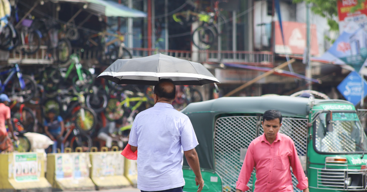তীব্র রোদ থেকে বাঁচতে ছাতা মাথায় পথচারীরা।